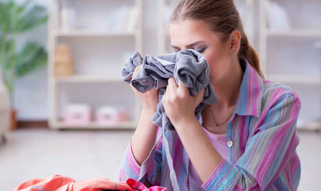 white lady sniffing clothe with nice perfume